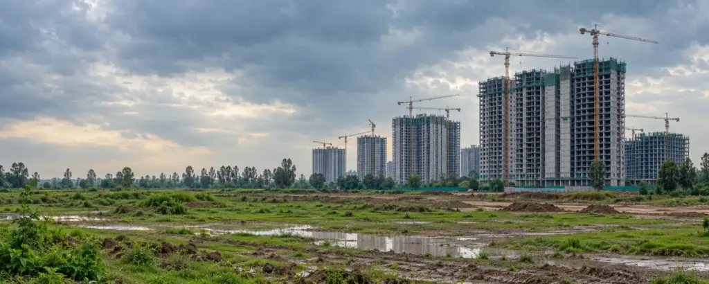 How to File a Complaint with UP RERA Against a Builder or Colony Developer: unfinished apartment towers with cranes under a